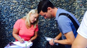 Robert Street with John L. Scott Foreclosures shows an auctioneer his money at the foreclosure auction that takes place outside the King County courthouse in downtown Seattle every Friday.