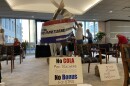 Retired Ohio teachers put up a banner during a break in a meeting of the State Teachers Retirement System board meeting in September 2022. Some of the teachers had been coming to board meetings for months to protest the suspension of the COLA in 2017.