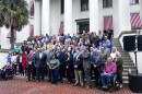 Photo of members of rural counties standing in front of old capitol building with Bobby Payne