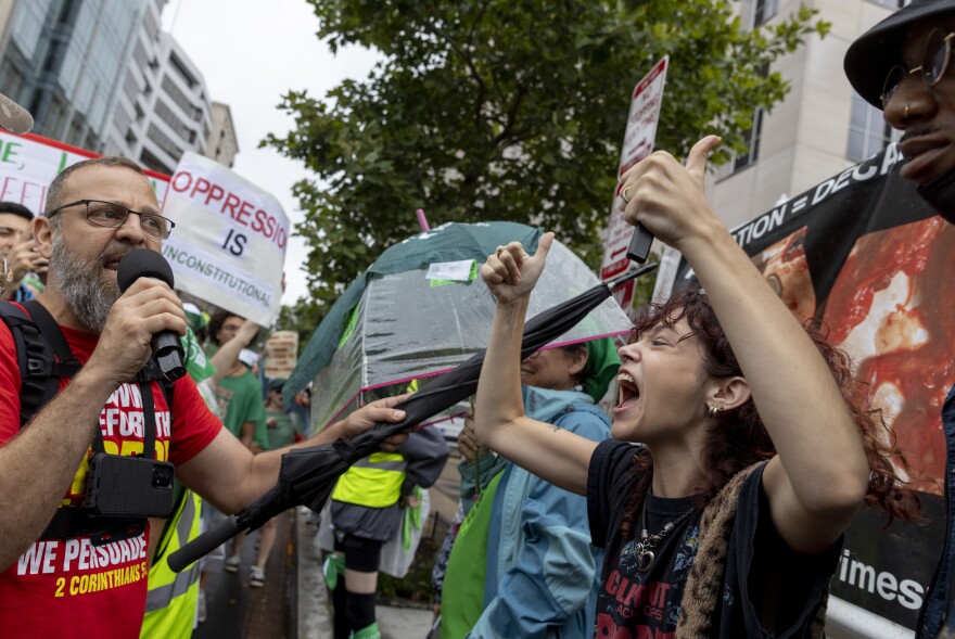 A Women's March participant, right, confronts an anti-abortion protester, left, along the route.