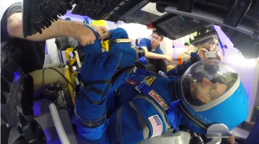Former Shuttle Astronaut and Boeing's Director of Crew & Mission Systems tests out the pressure suit in a Starliner mock-up. Photo: Boeing