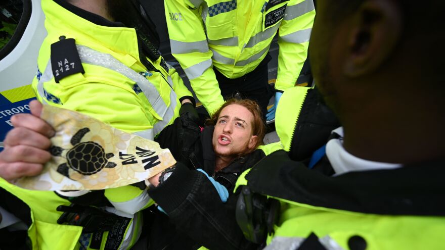 A protester gets hauled away by police Monday in London, where the climate change advocacy group Extinction Rebellion has scheduled nonviolent protests chiefly in Europe, North America and Australia over the next fortnight.