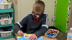 A Bess Elementary student works on an art project while wearing a face covering.