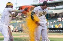 A baseball player dumps a cooler of liquid over another player
