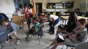 Art teacher Lindsay Johnson, center, has students explore how to use generative AI features in Canva at Roosevelt Middle School, Wednesday, June 25, 2025, in River Forest, Ill. (AP Photo/Nam Y. Huh)