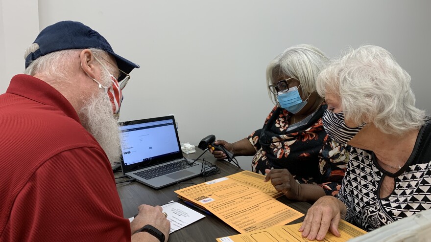 Election judges (from left) Bob Teel, Joanna Dodd and Dorothy Williams evluate signatures on vote-by-mail envelopes.