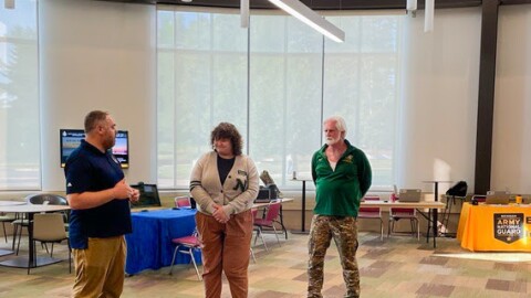 Joe Saur, MVAA education analyst, presents the MVAA Coin of Excellence to Madi Spychalla, NMU Student Support Servcies Program assistant, with Mike Rutledge, NMU Veteran Services coordinator.