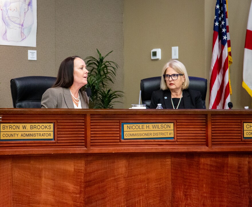 District 2 Commissioner Christine Moore (right) listens as Orange County District 1 Commissioner Nicole Wilson speaks at Tuesday's commission meeting.