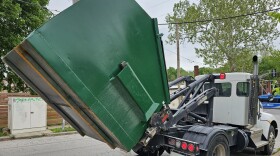 A full dumpster is hauled away to make room for an empty replacement.