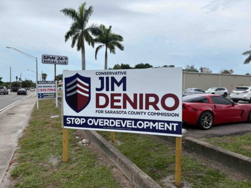 Campaign sign with cars driving by 