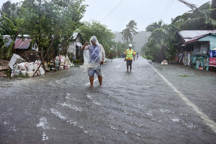 Residents of Pagnamitan, Guiuan, Eastern Samar, eastern Philippines wade through a flooded road caused by Typhoon Rai on Dec. 16.