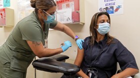 Licensed vocational nurse Denise Saldana vaccinates Pri DeSilva, associate director of Individual and Corporate Giving, with a fourth Pfizer COVID-19 vaccine booster at the Dr. Kenneth Williams Health Center in Los Angeles, Nov. 1, 2022.