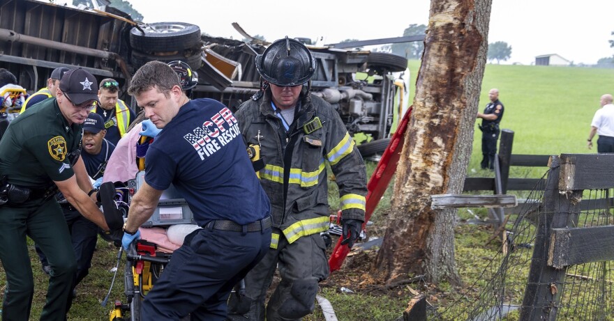 Crews from Marion County Fire Rescue and the Marion County Sheriff’s Office moving a person on a stretcher away from an overturned bus.