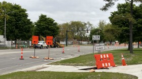 Road signs marking detours and sidewalk closures on a Michigan State University campus street