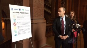 Alex Camarda, of Reinvent Albany, displays a chart listing potential reforms to clean up state government 