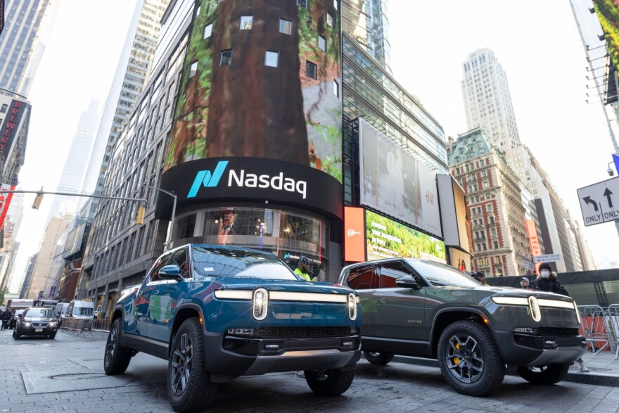 Two Rivian Electric Adventure Trucks sit parked in Times Square, New York.
