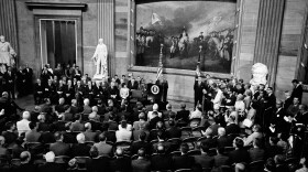 Black and white photo of President Lyndon Johnson at a podium speaking in the rotunda of the Capitol in Washington