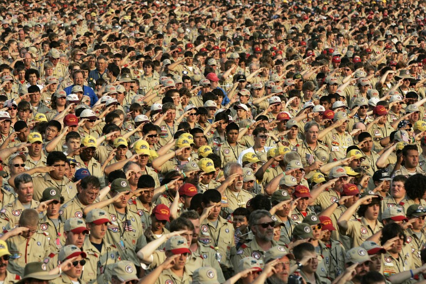 In this July 31, 2005 file photo, Boy Scouts salute as they recite the Pledge of Allegiance during the Boy Scout Jamboree in Bowling Green, Va. In 2019, financial threats to the Boy Scouts have intensified.