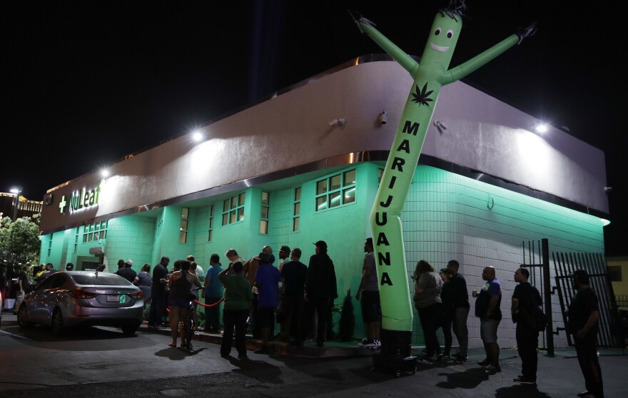 People line up outside a marijuana dispensary July 1, 2017.