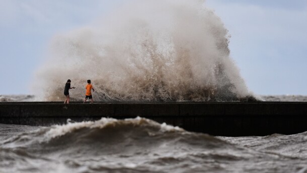 Children play near breaking waves on West End Pier on Lake Pontchartrain as Tropical Storm Bertha approaches the Louisiana Coast Wednesday, July 22, 2026, in New Orleans. (AP Photo/Gerald Herbert)