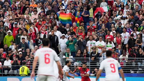 A spectator displays a rainbow Pride flag during a World Cup soccer game.