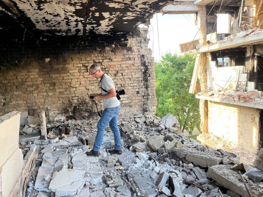 Patrick Patterson steps over rubble in a building in Ukraine.