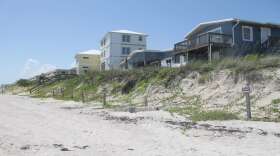 In Satellite Beach homes perch atop a sand dune, left exposed after a series of storms and hurricanes washed away a sea wall.