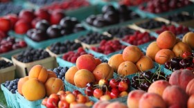 Fresh fruit in blue cartons at a farmers market