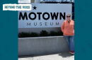 A woman wearing sunglasses smiles next to the Motown Museum sign.