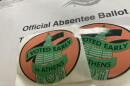 Two early voting stickers laid over an official absentee ballot