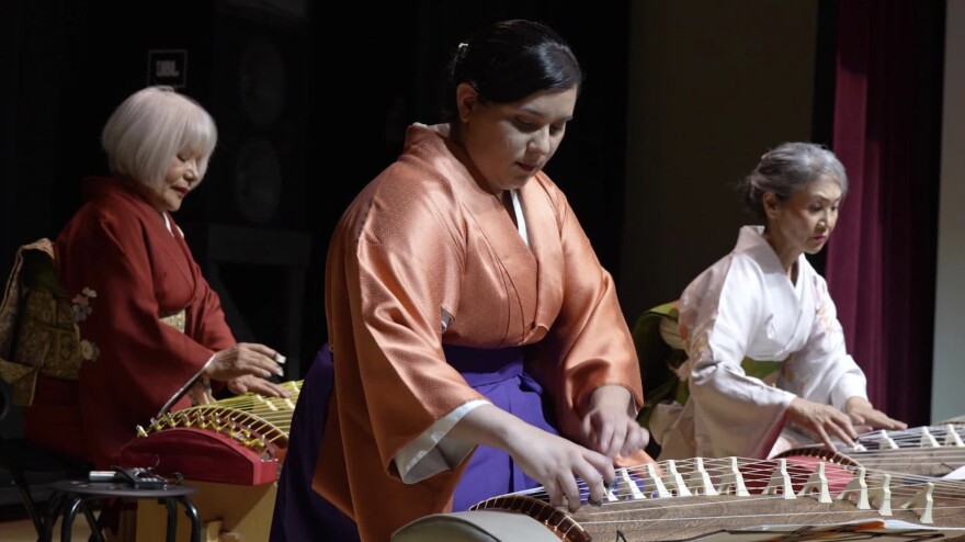 Musicians playing koto music on Japan’s national plucked zither instrument.