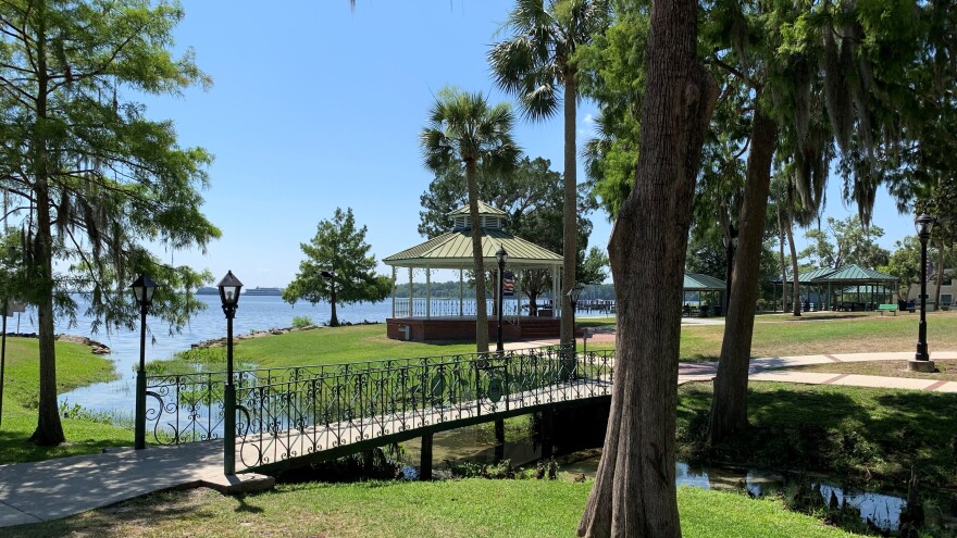 A small bridge crossing over a ravine that leads to the St. Johns in Green Cove Springs, trees and a gazebo in the background