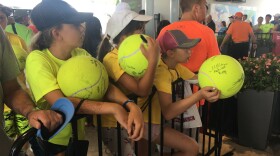 Campers from a tennis camp near Chicago wait in line for autographs in Mason.