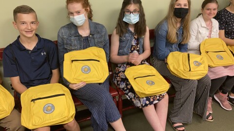 Students hold their backpacks supporting school choice legislation.
