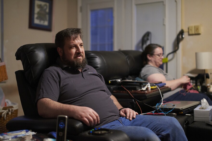 Drew Lehman and his wife, Laura, sit on the family's big leather couch. Lehman says it's the most comfortable place for him.