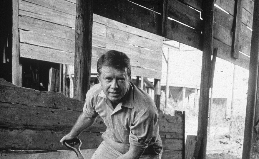 Carter shovels peanuts on a peanut farm in the 1970s. When his father died in 1953, Carter left his Navy career to run the family peanut farm in Georgia.