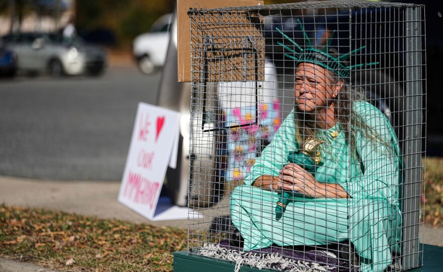 Shana Blake sits in a cage dressed as the Statue of Liberty to protest federal law enforcement presence in Charlotte, N.C. Monday, Nov. 17, 2025.