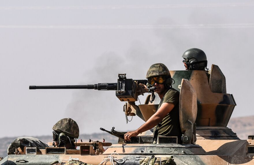 Turkish soldiers sit on a tank driving to Syria from the Turkish-Syrian border city of Karkamis on Saturday. Turkey's army has launched an operation in northern Syria to drive Islamic State fighters out of the border area.