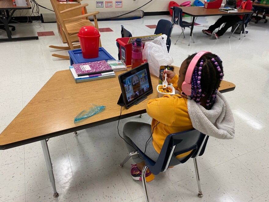 An Oakdale Elementary first-grader eats breakfast while doing an online lesson in class.