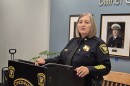A woman in a police uniform stands at a podium
