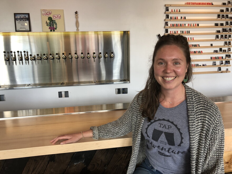Carolyn Stiles, of Rochester Beer Gals, poses in front of taps at Fifth Frame Brewing