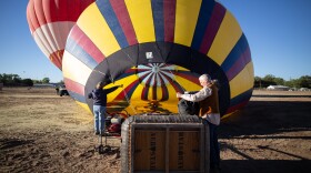 Pilot Gary Michalek checks on-board equipment while a noisy fan inflates his balloon