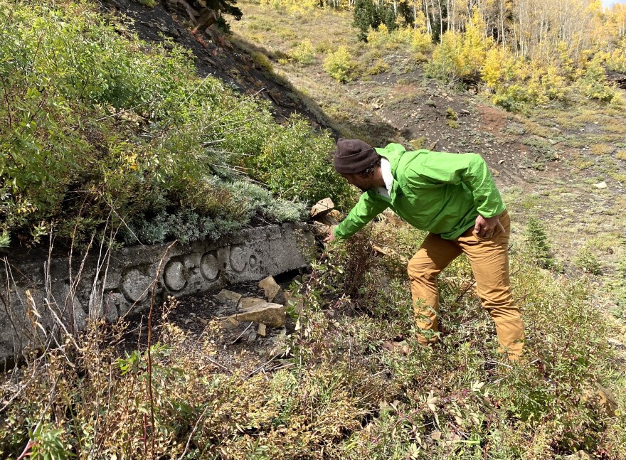 Paonia-based climate scientist Chris Caskey points at the top of an old Mid-Continent Coal and Coke Company mine shaft that’s leaking methane out of a hole in the porous rock. Air coming out of the mine is strong enough to move nearby vegetation and on this day consisted of almost 2% methane by volume, according to Caskey.