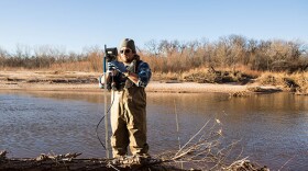 Oklahoma Water Resources Board project coordinator Jason Murphy takes water samples at the Canadian River east of Oklahoma City.