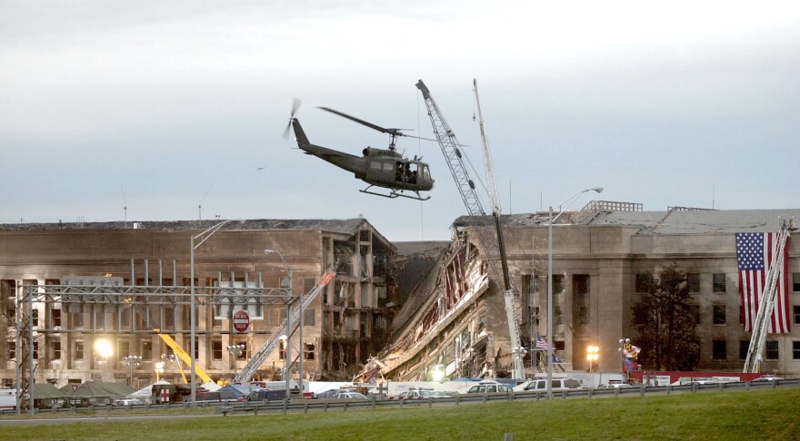 A military helicopter flies in front of the Pentagon September 14, 2001 in Arlington, Virginia at the impact site where a hijacked airliner crashed into the building.  (Stephen J. Boitano/Getty Images)