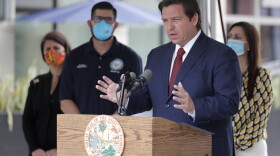 Florida Gov. Ron DeSantis, right, speaks at a news conference during the new coronavirus pandemic, Thursday, May 14, 2020, in Doral, Fla. DeSantis has signed an executive order for the reopening of Miami-Dade and Broward counties on May 18.