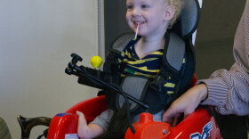 A small child tries out a new mobility device.