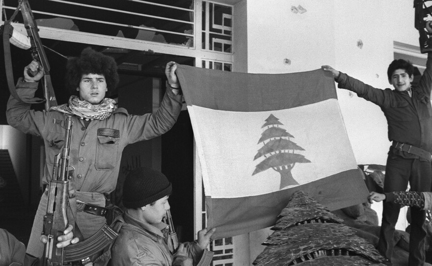 Palestinian fighters unfurl a Lebanese flag at the Holiday Inn after they dislodged Lebanese Christian forces on March 26, 1976. The hotel was a battleground throughout the 1975-'90 Lebanese war, with its upper floors used as snipers' nests.