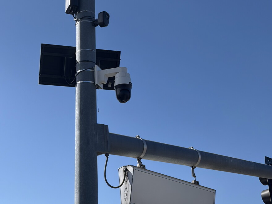 Surveillance cameras mounted to  a lightpole. 