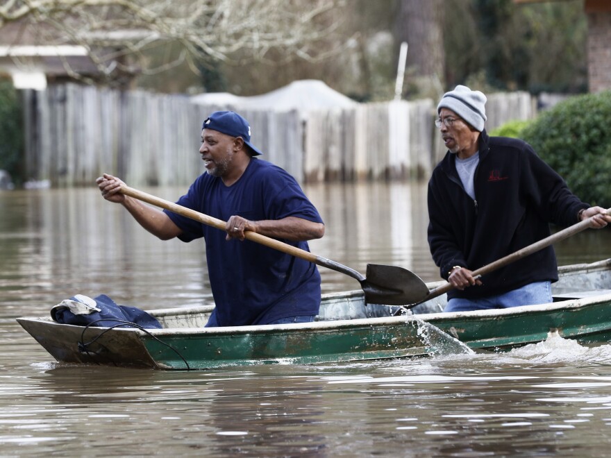 Jackson, Miss., residents use shovels to work their way through Pearl River floodwaters on Sunday.